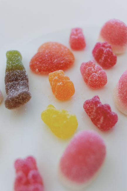 Brightly colored gummy candies on a white background, highlighting sugary textures.