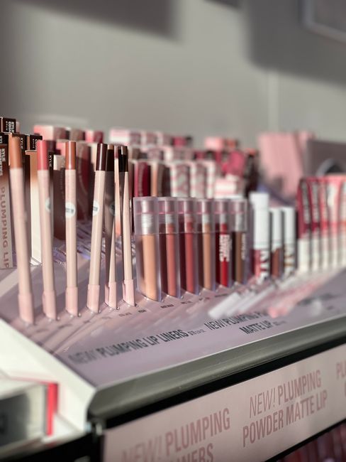 Vibrant display of lip liners and gloss in a retail store, showcasing diverse colors.