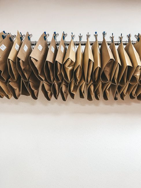 Brown packages neatly organized on metal hangers with a clean white background.