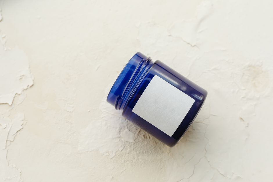 Simple blue container with label on a textured white background, perfect for mock-ups or product presentations.